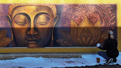 Siddharthas Weg zur Erleuchtung – ein goldener Buddha erstrahlt an der Fassade eines Wohnhauses